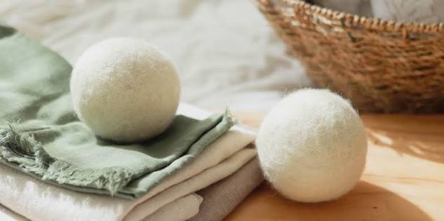 Wool dryer balls beside folded laundry